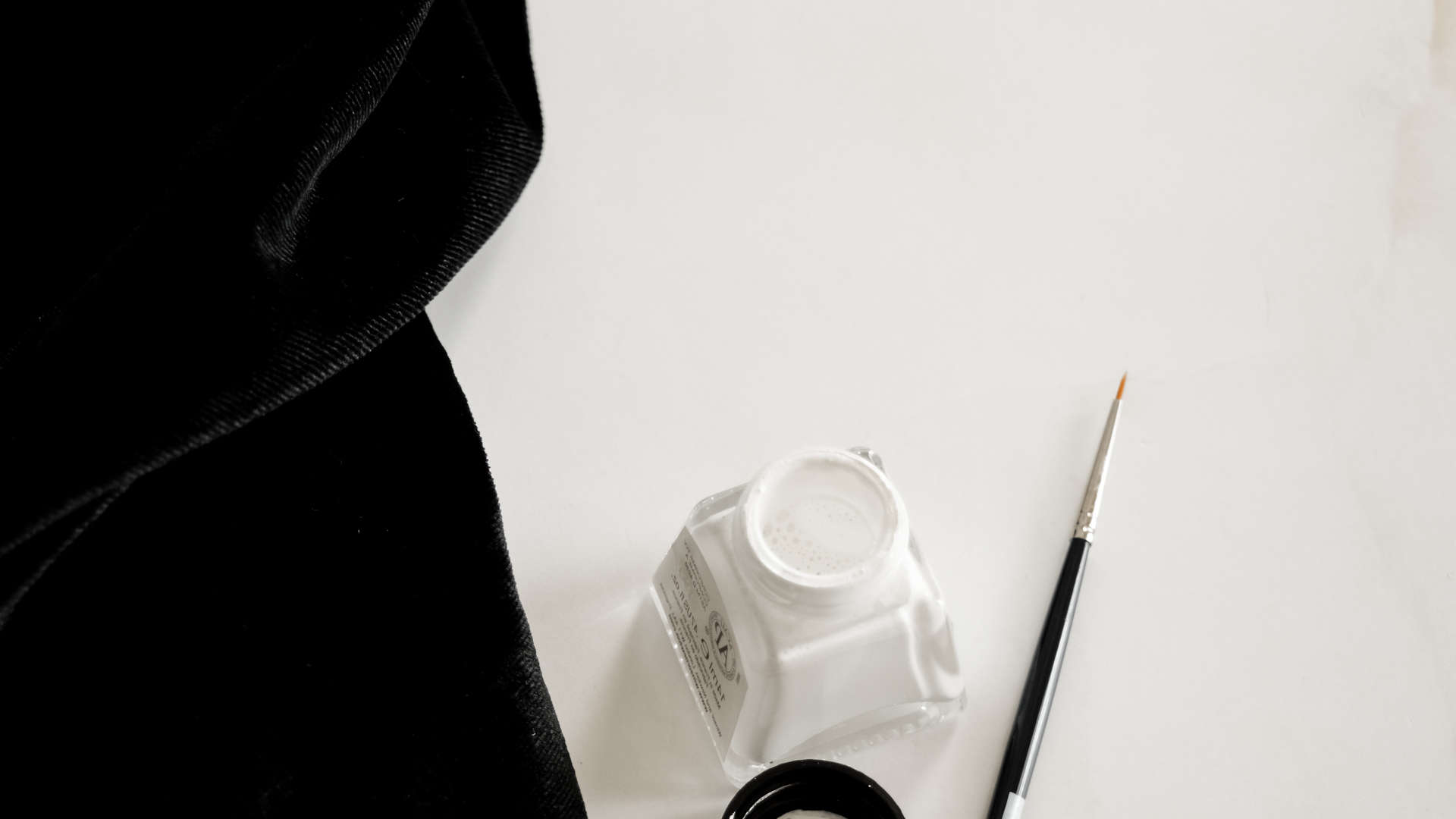 white ink and paint brush and black velvet by hanli