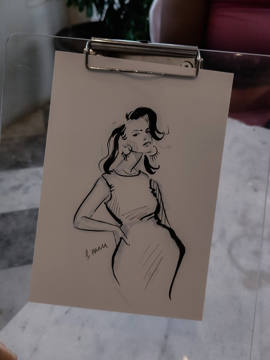 A photo of a live event sketch of a guest attending a wedding. The sketch is completed in 5-10min while the guest watches the process and took the sketch home from a wedding in Stellenbosch. By artis Hanli