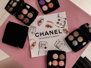 A flatlay of CHANEL Les 4 Ombres Bouton eyeshadow palettes and a eye and beauty product sketches on a CHANEL paper at an in store event in Cape Town by artist, Hanli.